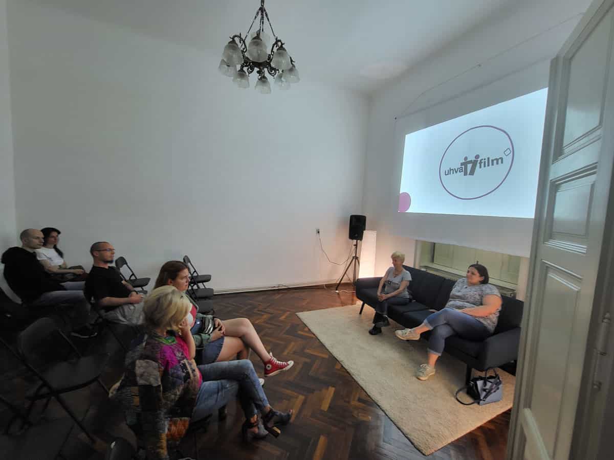 Milesa Milinković, direktorka Uhvati film i Marijana Ramić, moderatorka diskusija sede na kauču. Iza njih na platnu projektivan logo Uhvati film-a u krugu. Pored njih je zvučnik. Ispred je publika.